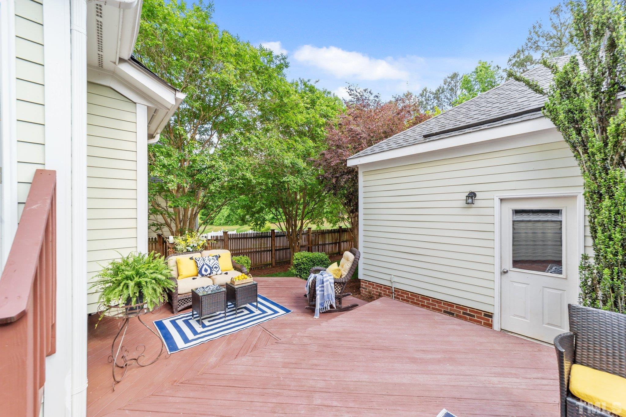145 Kingsport Road Holly Springs, NC 27540 - Photo 27 of 42 a view of a patio with a table and chairs and potted plants