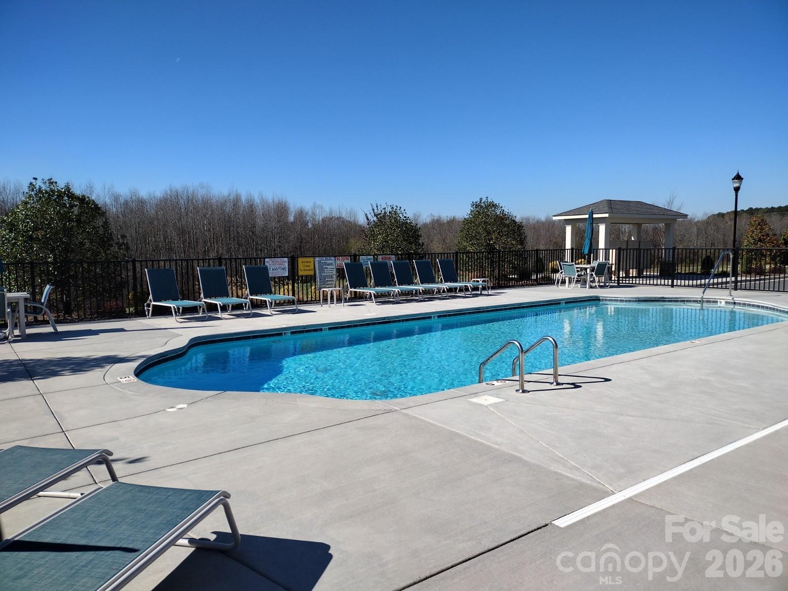 9049 Treetop Way Northwest Concord, NC 28027 - Photo 40 of 42 a view of a swimming pool with lounge chairs