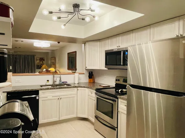 a kitchen with granite countertop a sink stove and microwave