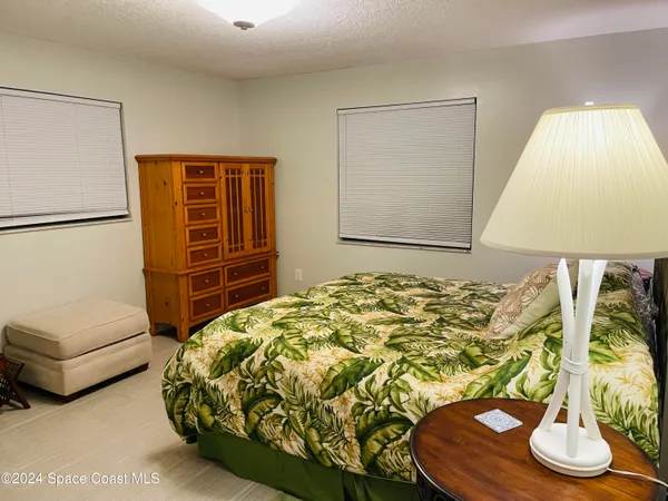 a bed sitting in a bedroom next to a lamp