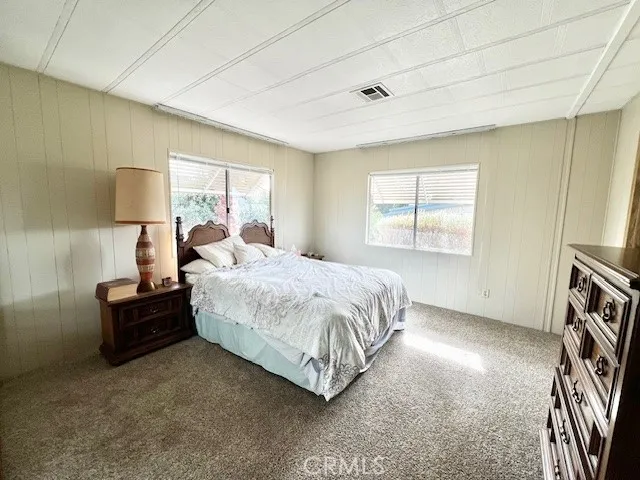 a spacious bedroom with a bed window and a night stand