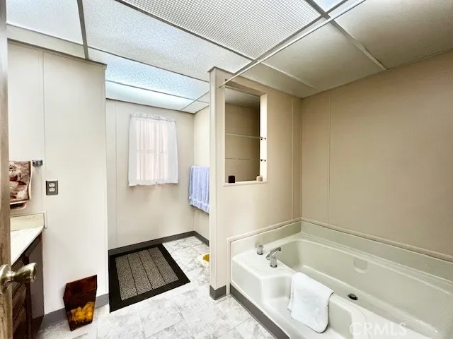 a bathroom with a tub a sink and a mirror