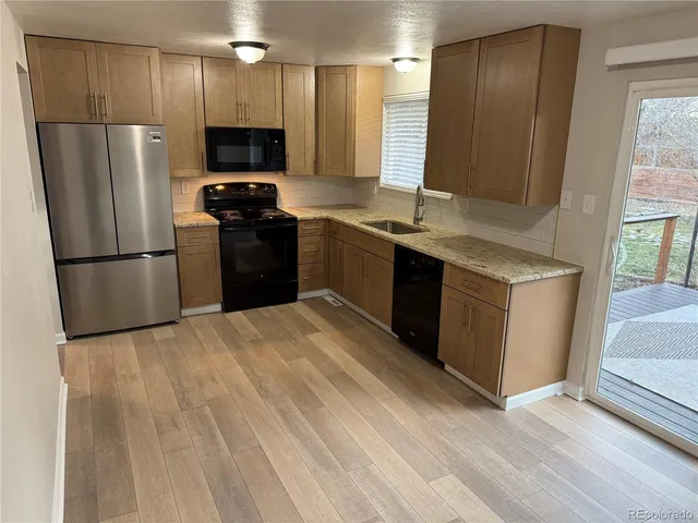 a kitchen with a refrigerator a microwave a sink and a stove