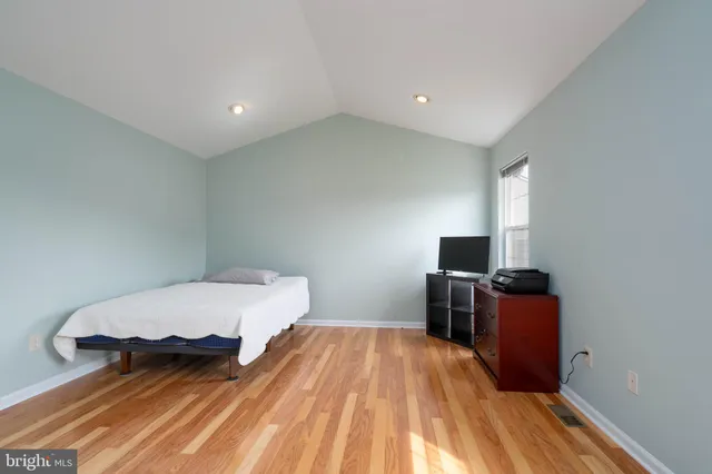 a bedroom with a bed and wooden floor