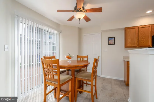 a dining room with furniture and a chandelier fan