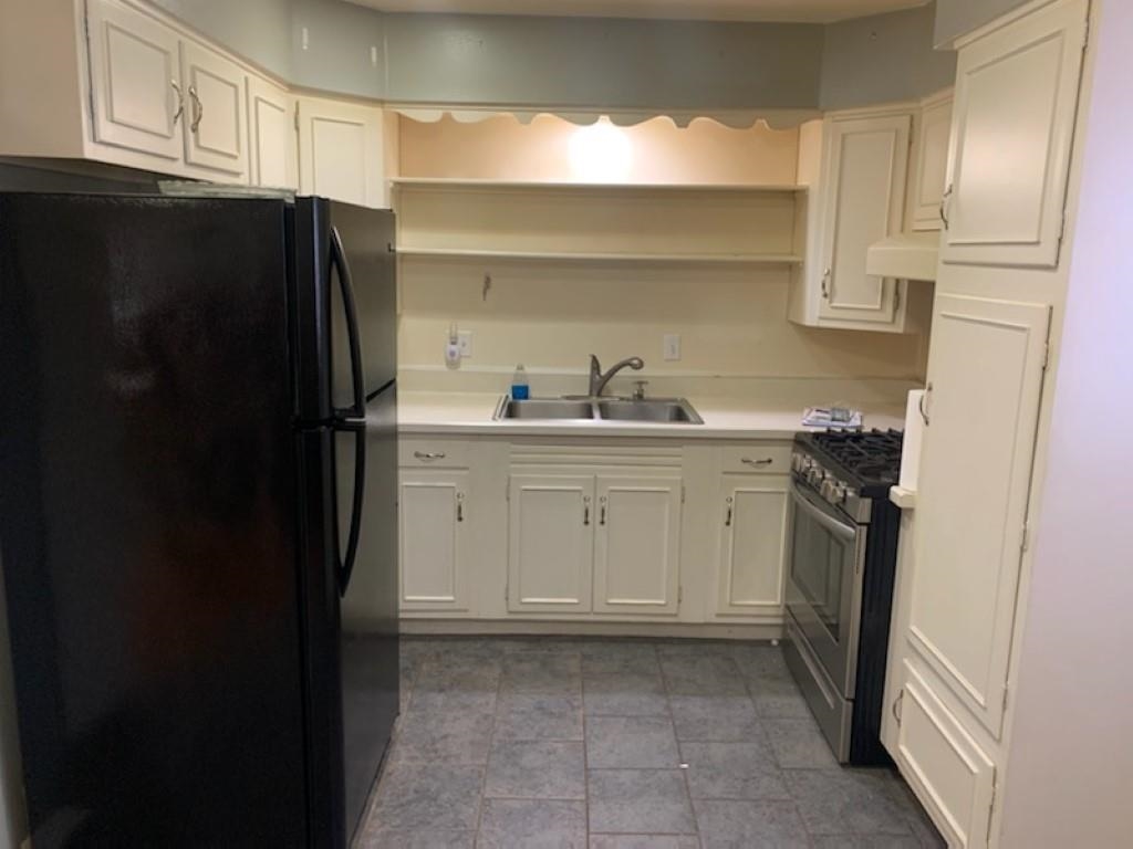 5015 Highcrest Road Rockford, IL 61107 - Photo 5 of 12 a kitchen with a sink a refrigerator and cabinets