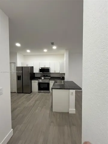 a kitchen with a sink and white cabinets