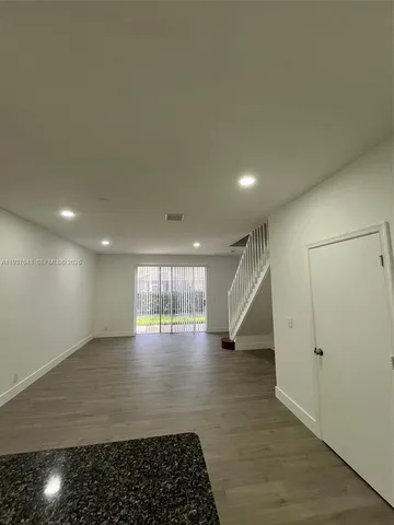 an empty room with wooden floor and entryway