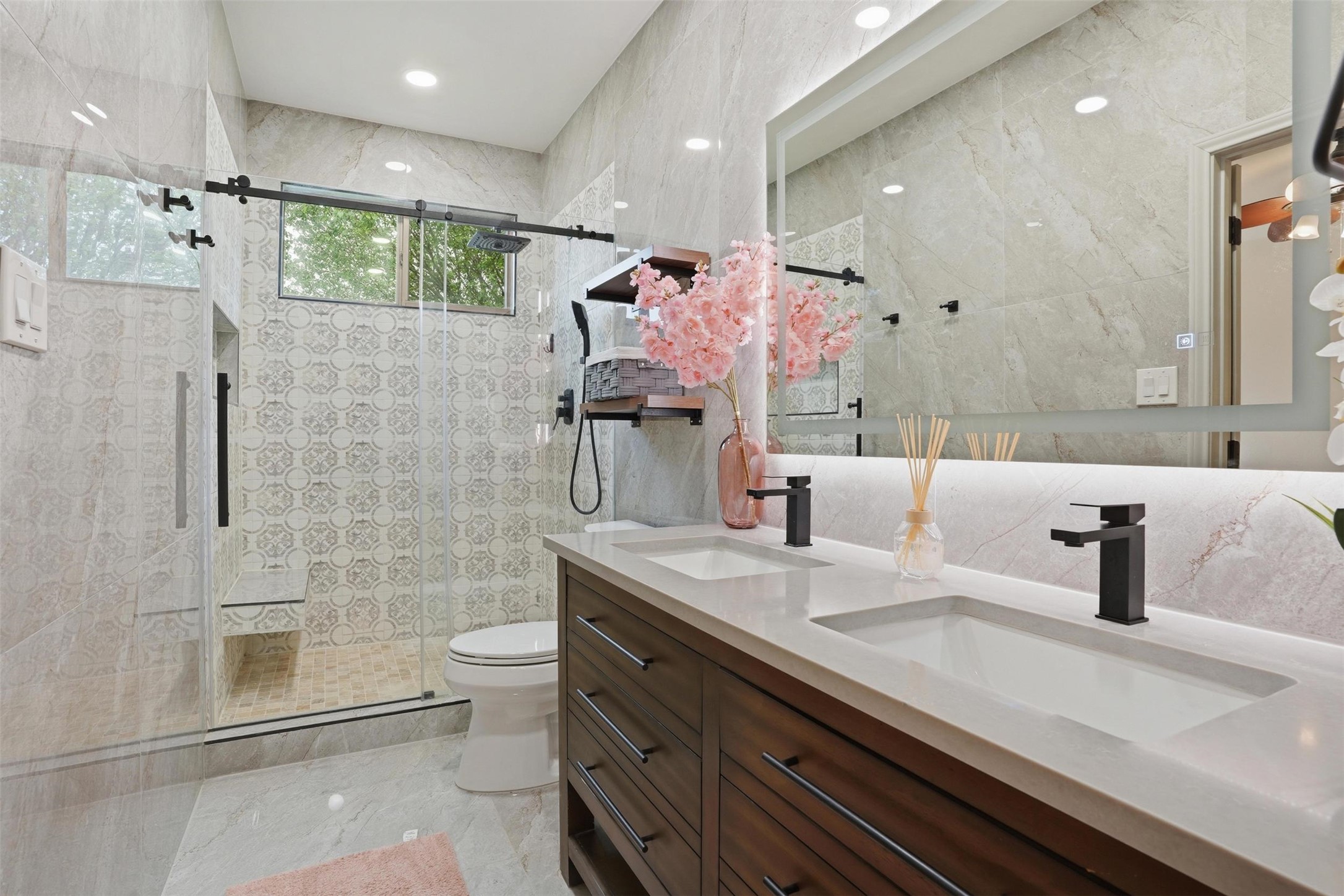 11606 Murchison Street Manor, TX 78653 - Photo 13 of 35 The property features a contemporary bathroom with a double vanity, sleek black fixtures, and an illuminated mirror