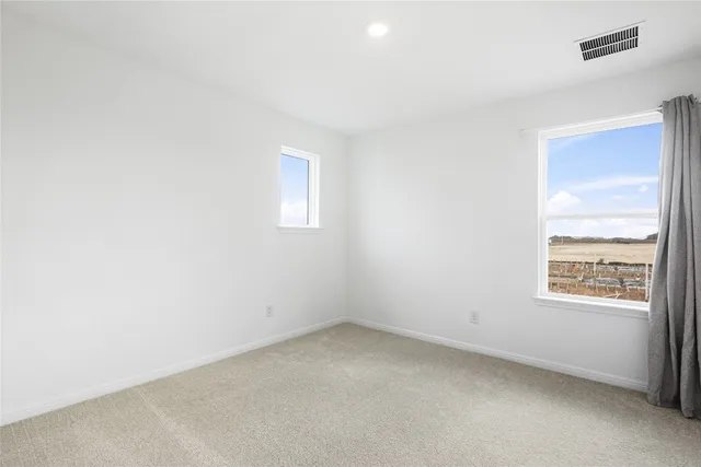 an empty room with a ceiling fan and a window