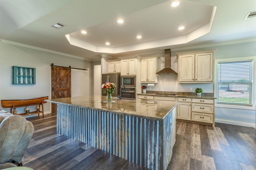14910 Old Stoney Road Ponder, TX 76259 - Photo 7 of 36 a kitchen with granite countertop a stove and a wooden floors