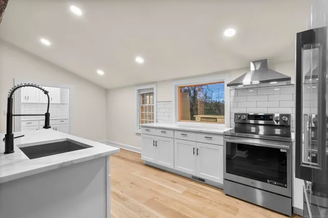 a large kitchen with lot of cabinets and wooden floor
