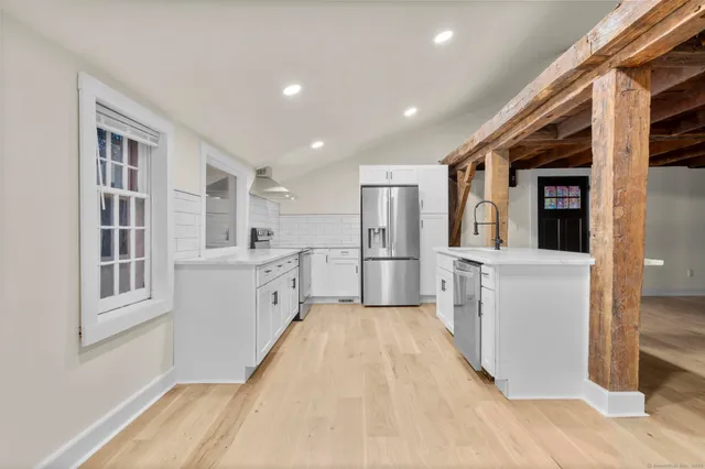 a view of a kitchen with white cabinets and wooden floor
