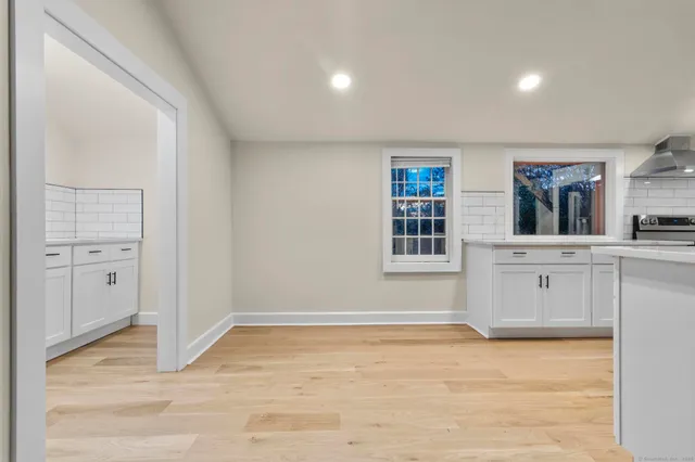a kitchen with white cabinets and sink