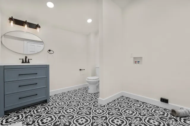 a bathroom with a sink a toilet and shower