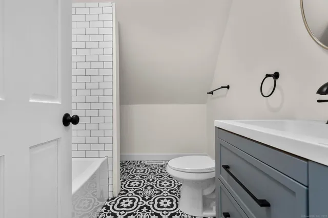 a bathroom with a toilet a sink and a mirror