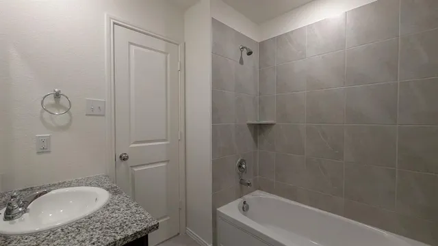 a bathroom with a granite countertop sink a toilet and bathtub