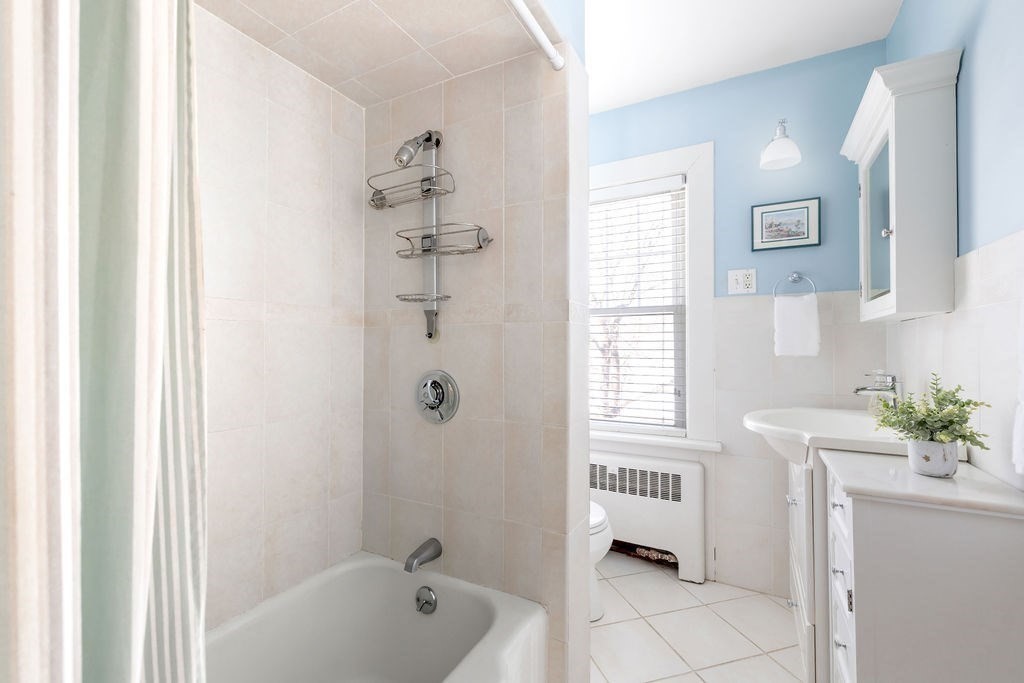 60 High Street Needham, MA 02494 - Photo 23 of 32 a bathroom with a bathtub a sink a window and a shower