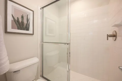 a bathroom with a painting on the wall and shower