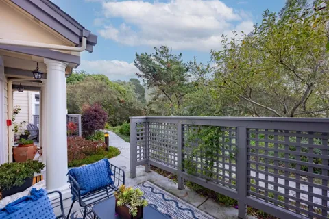 a view of a balcony with chairs and wooden fence