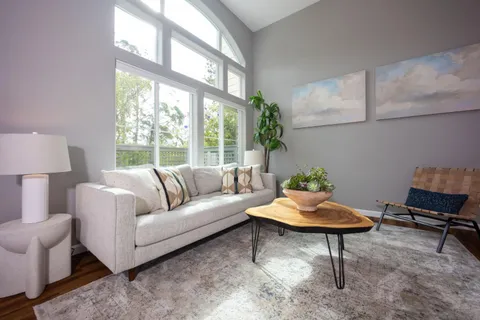 a living room with furniture a lamp and a window