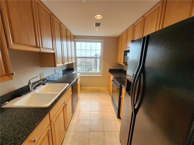a kitchen with stainless steel appliances granite countertop a refrigerator and a stove