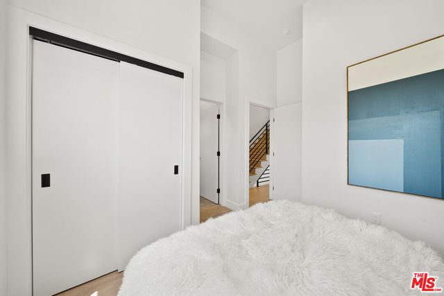 a bedroom with a bed and a large mirror