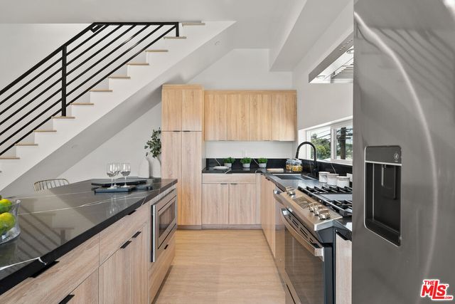a kitchen with stainless steel appliances granite countertop a sink stove and refrigerator
