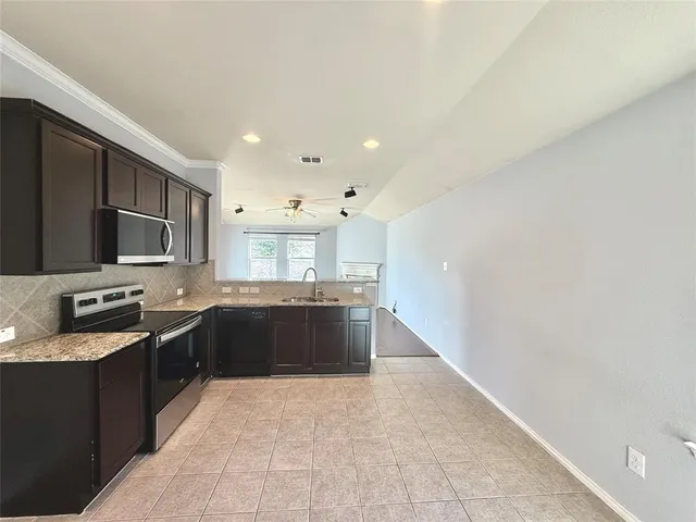 a kitchen with granite countertop a stove and a sink