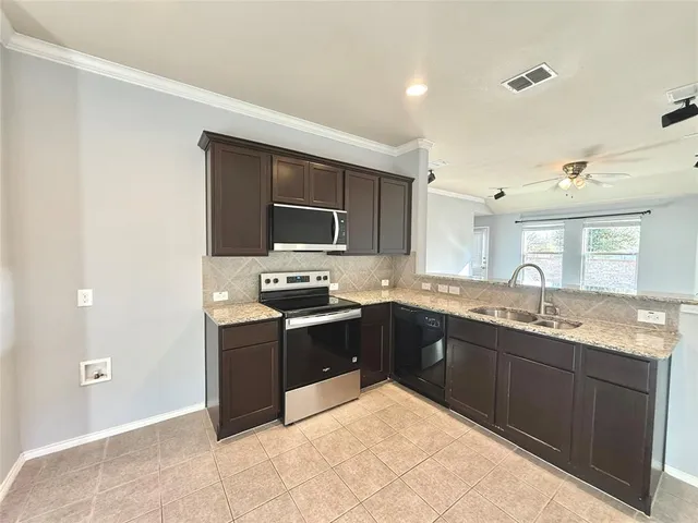 a kitchen with stainless steel appliances granite countertop a sink stove and refrigerator