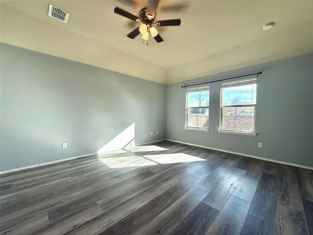 a view of a room with wooden floor and ceiling fan