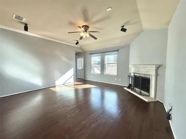 a view of empty room with fireplace and wooden floor