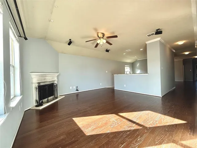 a view of a livingroom with a fireplace a chandelier and wooden floor