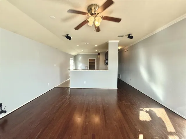 a view of a livingroom with a ceiling fan and wooden floor