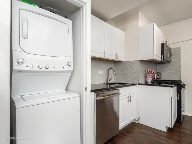 a kitchen with stainless steel appliances granite countertop a sink and a stove