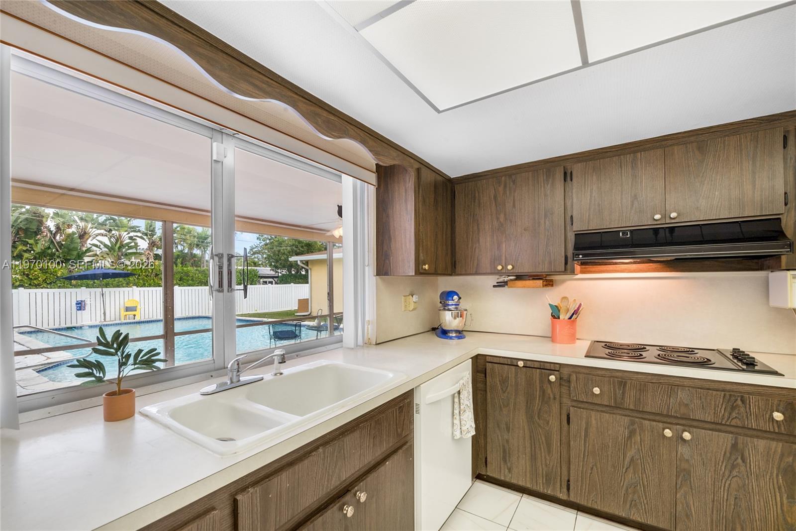 4931 Madison Street Hollywood, FL 33021 - Photo 11 of 26 a kitchen with wooden cabinets a sink and a stove
