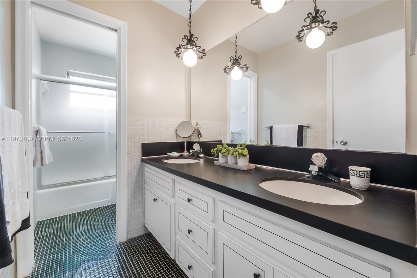 4931 Madison Street Hollywood, FL 33021 - Photo 14 of 26 a bathroom with a granite countertop sink a light fixture and a mirror