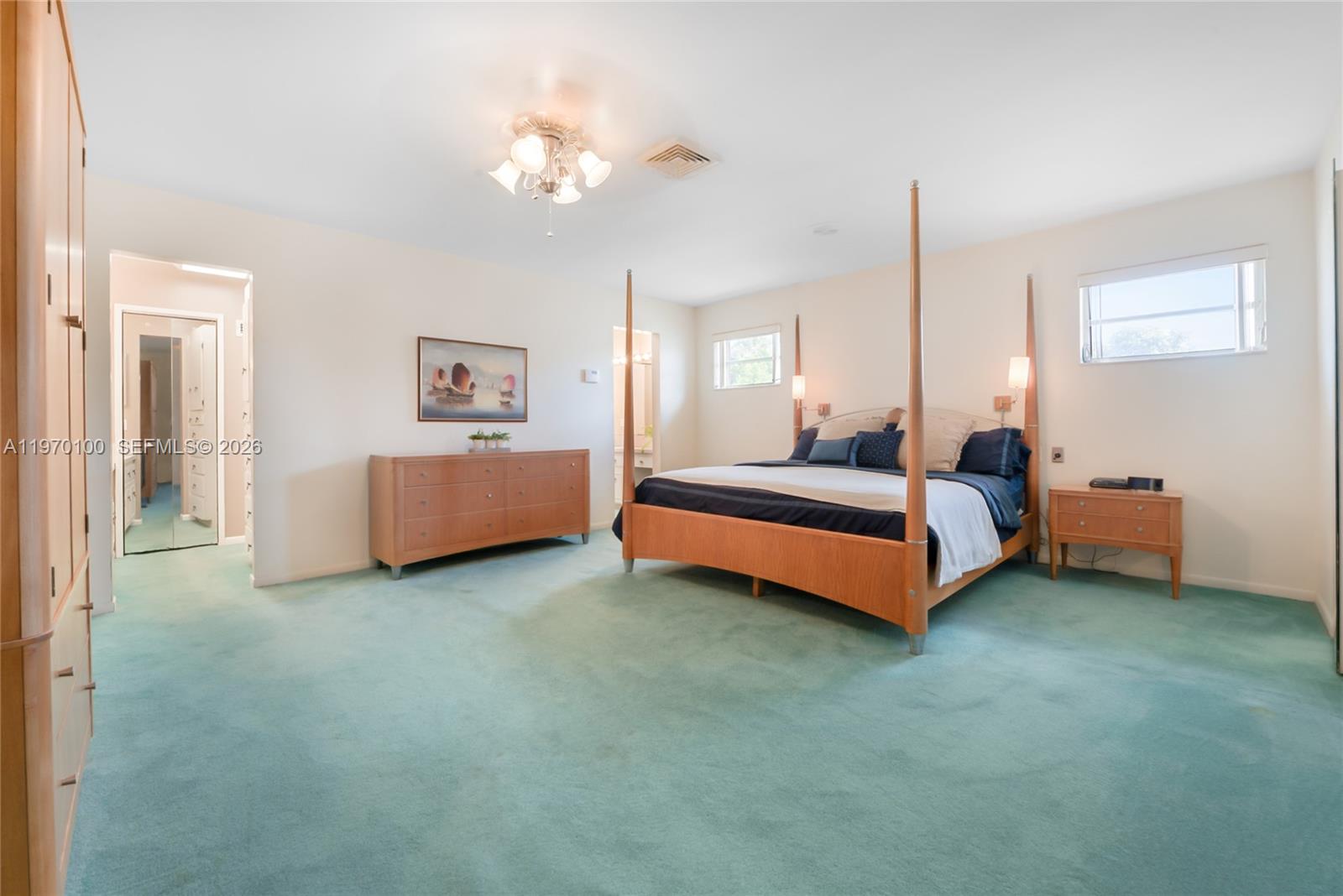 4931 Madison Street Hollywood, FL 33021 - Photo 16 of 26 a spacious bedroom with a bed and a chandelier