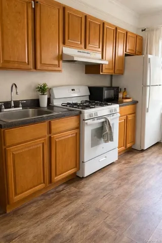 a kitchen with stainless steel appliances granite countertop a stove a sink and a refrigerator