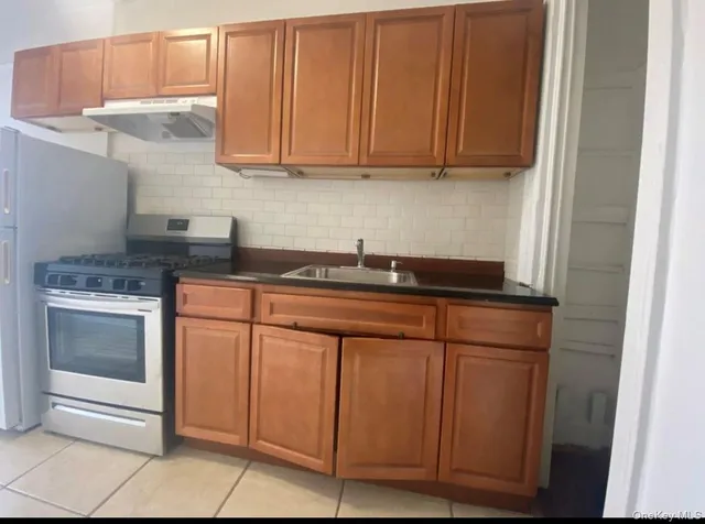 a kitchen with granite countertop white cabinets and stainless steel appliances