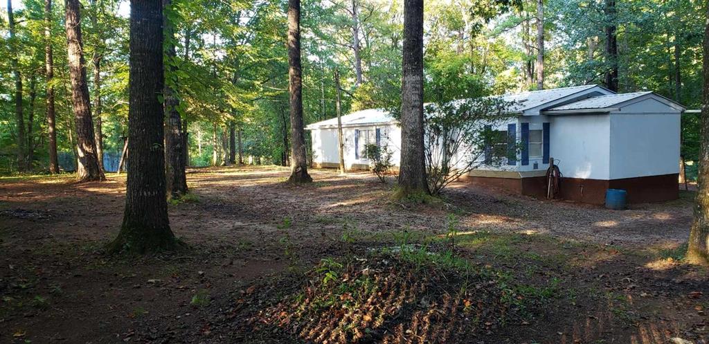 125 Sputnik Street Fortson, GA 31808 - Photo 25 of 30 a view of a house with large trees and a barn