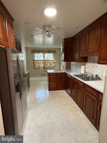 a kitchen with stainless steel appliances granite countertop a refrigerator a sink a stove a microwave and island