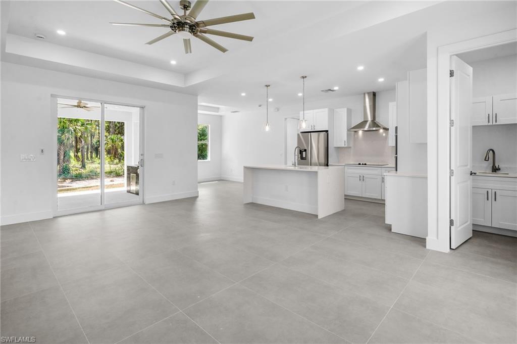 2712 40th Avenue Southeast Naples, FL 34117 - Photo 12 of 41 a view of a kitchen with a sink and dishwasher a refrigerator with wooden floor