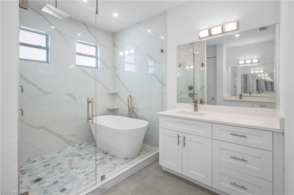 2712 40th Avenue Southeast Naples, FL 34117 - Photo 17 of 41 a spacious bathroom with a double vanity sink a mirror and a shower