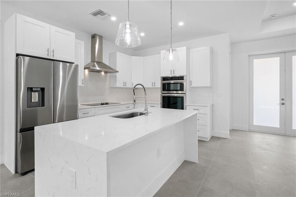 2712 40th Avenue Southeast Naples, FL 34117 - Photo 7 of 41 a large kitchen with a large counter top appliances and cabinets