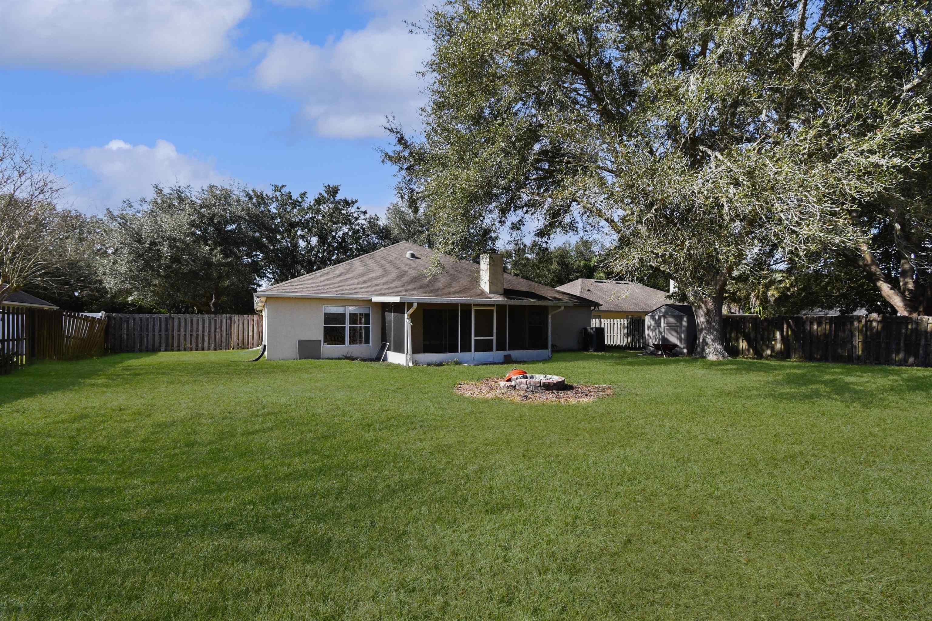 420 Bay Point Way North St. Johns, FL 32259 - Photo 7 of 37 Back of house featuring a fenced backyard, a sunroom, a chimney, and a storage shed
