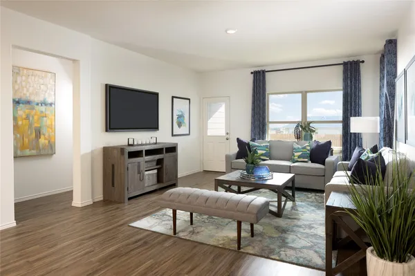 a living room with furniture a flat screen tv and a large window