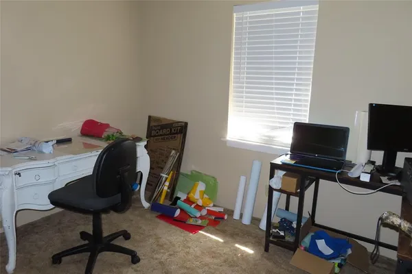 a view of a workspace with furniture and a window