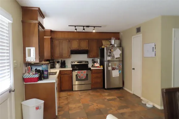 a kitchen with stainless steel appliances a stove a refrigerator and a sink