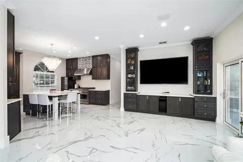a living room with stainless steel appliances furniture and a flat screen tv